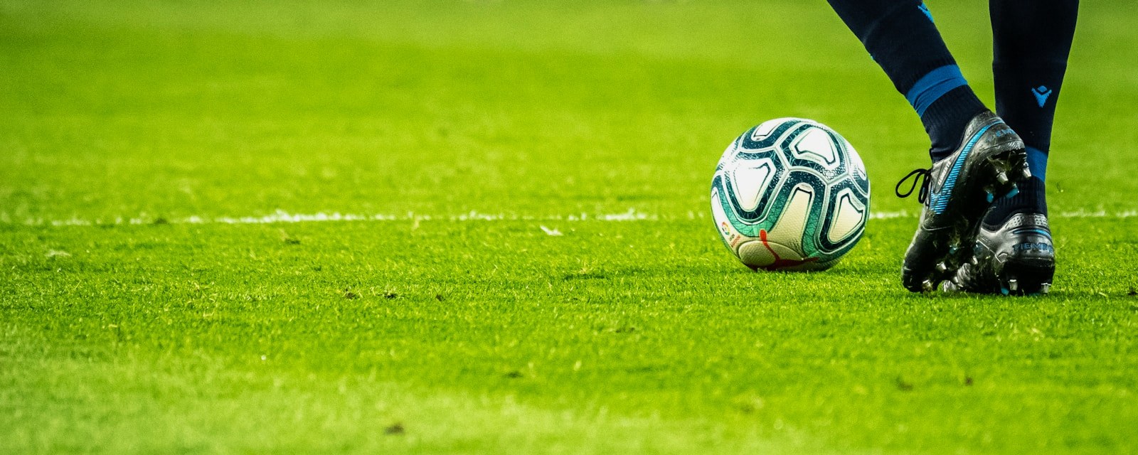 Pelota de fútbol sobre el césped — inteligencia artificial aplicada a las apuestas deportivas
